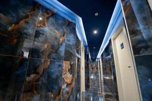 Cette chambre est dotée d'un mur recouvert de marbre. dans l'établissement PC Boutique H Loggia, by ClaPa Group, à Naples