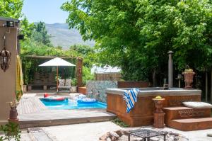 a backyard with a pool with a table and an umbrella at Art Box in Greyton
