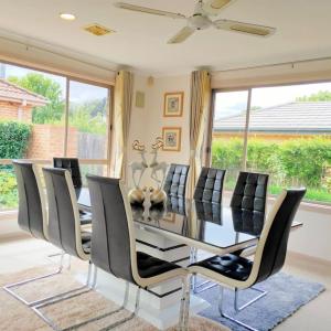 a dining room with a table and chairs at Parliament Triangle * Garden View in Yarralumla