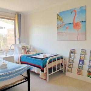 a bedroom with a bed and a flamingo painting on the wall at Parliament Triangle * Garden View in Yarralumla