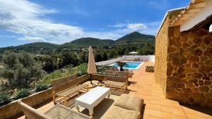 a patio with a table and chairs and a pool at Finca Can Toni den Real in Sant Josep de sa Talaia