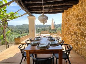 a dining room with a table and chairs on a patio at Finca Can Toni den Real in Sant Josep de sa Talaia