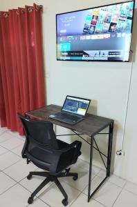 a laptop computer sitting on a desk with a chair at Tropix Getaway - rental car available in Crocus Hill