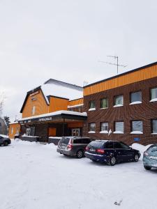 a group of cars parked in a parking lot in front of a building at Rentalux Hostel in Timrå