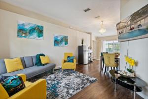 a living room with a blue couch and yellow chairs at Master Guest Suite with Pool and Private Entrance Minutes to Parks in Orlando