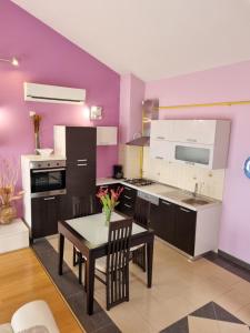 una cucina con pareti viola, tavolo e sedie di Kvarner Golden view Apartments a Matulji (Mattuglie)