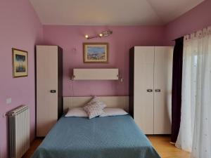 a bedroom with a bed and a purple wall at Kvarner Golden view Apartments in Matulji