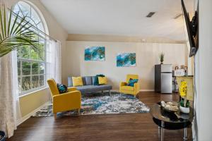 uma sala de estar com um sofá e cadeiras amarelas em Master Guest Suite with Pool and Private Entrance Minutes to Parks em Orlando