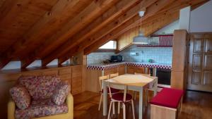 cocina con mesa y silla en una habitación en Deliziosa mansarda con vista Dolomiti, en San Vito di Cadore