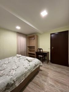 sypialnia z łóżkiem, stołem i biurkiem w obiekcie House on Ganja street w Kutaisi