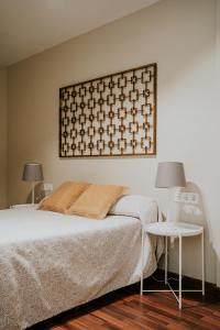 トレ・デル・マールにあるMares - Bellamarのベッドルーム1室(ベッド1台付)、壁にランプ2つ