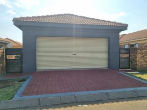 un garage con porta pieghevole in una casa di Sunny Estate a Katlehong