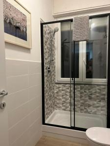 a bathroom with a shower with a glass door at ACCADEMIA Rooms in Livorno