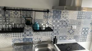 uma cozinha com azulejos azuis e brancos na parede em ACCADEMIA Rooms em Livorno