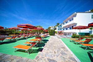 a row of lounge chairs and umbrellas at a hotel at Hotel La Mandorla in Ischia