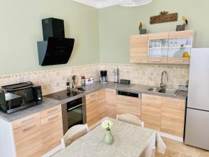 kuchnia ze stołem i białą lodówką w obiekcie Appartement L’olivier w mieście Draguignan