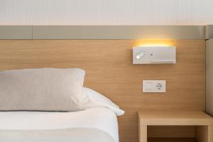 1 dormitorio con 1 cama y una luz en la pared en Hotel Samos en Magaluf