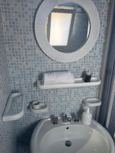 a bathroom with a sink and a mirror at Dirò Camere in Scoglitti