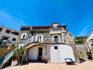 uma grande casa de tijolos com uma porta branca e escadas em YourHome - Relais Loggia Li Galli em Massa Lubrense