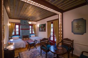 a bedroom with two beds and a table and chairs at Meliteion Traditional Hotel in Asprangeloi