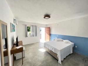 een slaapkamer met een wit bed en een blauwe muur bij Dlux Suites Baia Formosa in Baía Formosa