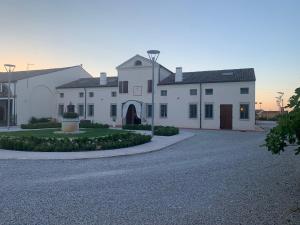 a large white house with a driveway at Possessioni Ferraresi in Melara