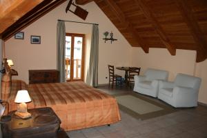 1 dormitorio con 1 cama, mesa y sillas en HOTEL LA GINESTRA en Cesana Torinese