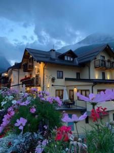 una casa con flores delante en HOTEL LA GINESTRA en Cesana Torinese