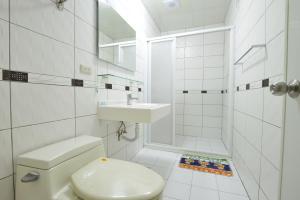 a white bathroom with a toilet and a sink at 回家浪 in Hengchun South Gate +94 photos