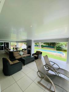 a large living room with a couch and chairs at LouwDownOnVaal in Vanderbijlpark