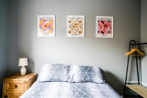 ein Schlafzimmer mit vier Bildern an der Wand in der Unterkunft Harrow Road Stay Central+Parking in Leicester
