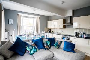 ein Wohnzimmer mit einem Sofa und blauen Kissen in der Unterkunft Harrow Road Stay Central+Parking in Leicester