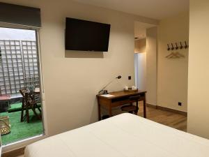 a bedroom with a bed and a desk and a television at PACOROOMS in Madrid +64 photos