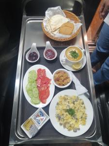 a tray of food with plates of food on it at Tribes hotel in Sohar