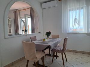 a dining room with a table and a mirror at Guest House Angela in Senj