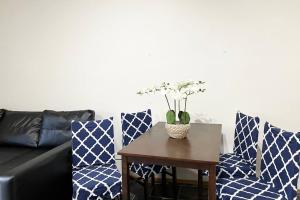 Private Unit underneath a family Home في Cherrybrook: غرفة معيشة مع أريكة وطاولة مع كراسي