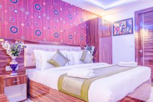 a bedroom with a large bed with a red wall at FabExpress Pearl Robe in New Delhi