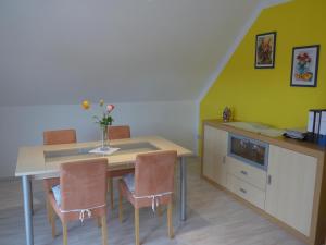 a dining room with a table with chairs and a cabinet at Ferienwohnung Ulbrich in Bautzen +7 photos