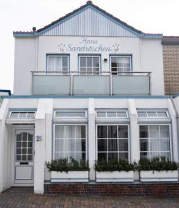 a white building with a sign on top of it at Haus Sandröschen in Norderney