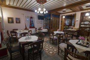 AsprangeloiにあるMeliteion Traditional Hotelのテーブルと椅子、シャンデリアのあるレストラン