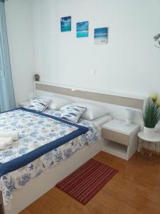 a bedroom with a bed and a white wall at Apartman Bruna in Novalja