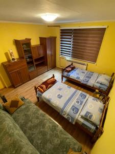Habitación con 2 camas y sofá. en Apartman Sara en Višegrad