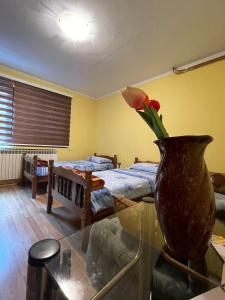 una habitación con un jarrón con una flor sobre una mesa de cristal en Apartman Sara en Višegrad