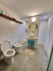 a bathroom with a toilet and a sink and a mirror at Casa en Camino del cuadrado Sierras de Córdoba in Río Ceballos