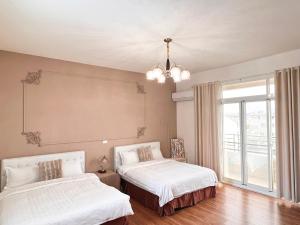 a bedroom with two beds and a large window at 永安101 Wing on x 附陽台 in Taitung City