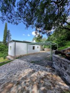 a view of a white building with a canopy at Casa en Camino del cuadrado Sierras de Córdoba in Río Ceballos