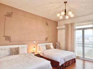 a bedroom with two beds and a large window at 永安101 Wing on x 附陽台 in Taitung City