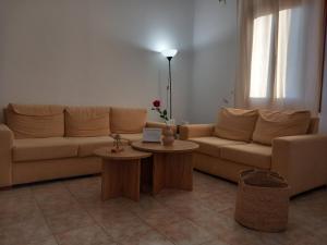 a living room with a couch and two tables at Korali in Symi