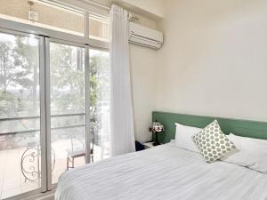 a bedroom with a bed and a large window at 永安101 Wing on x 附陽台 in Taitung City