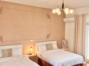 a bedroom with two beds and a chandelier at 永安101 Wing on x 附陽台 in Taitung City